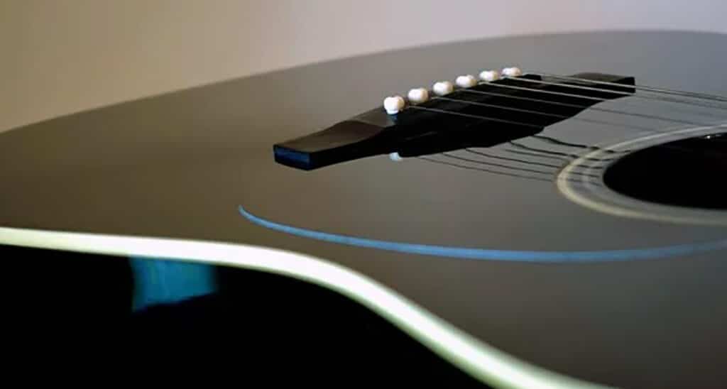 Light Vs Heavy Guitar Strings - Which Gauge Do You Need? Black Acoustic Guitar With Light Gauge