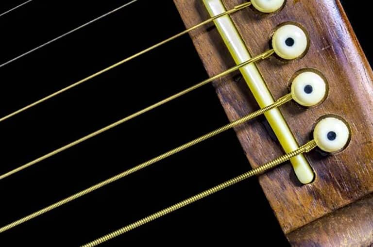 Light Vs Heavy Guitar Strings - Which Gauge Do You Need? Medium Gauge Strings On A Guitar Bridge