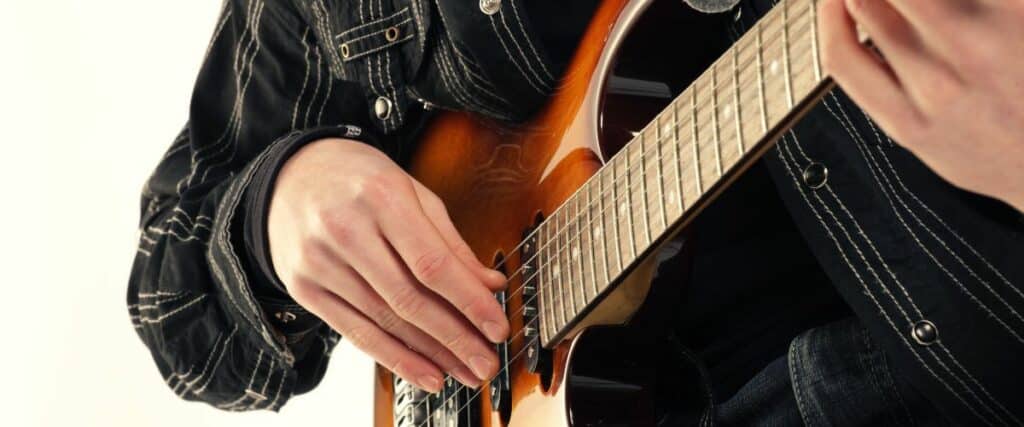 Stratocaster Review: Unveiling The Iconic Guitar'S Timeless Appeal A Electric Guitarist Hands Playing The A Sunburst Electric Guitar