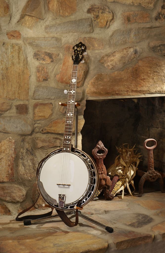 Is Banjo Hard To Learn? My Honest Opinion For Beginners A Banjo Placed On A Banjo Holder Near A Fire Place