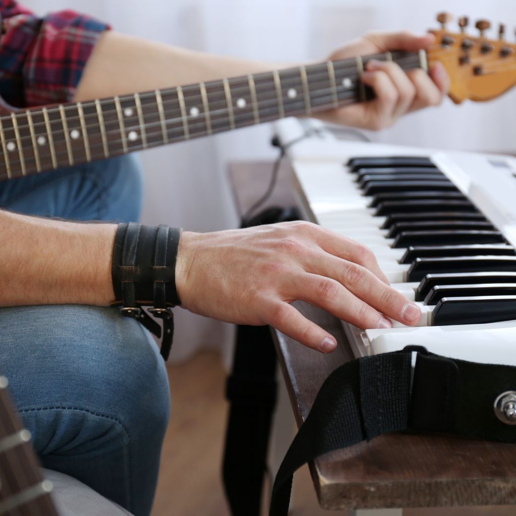 10 Crazy Things Guitarists Have Used To Play Solos—You Won'T Believe What’s On This List! An Electric Guitarist Using A Synth