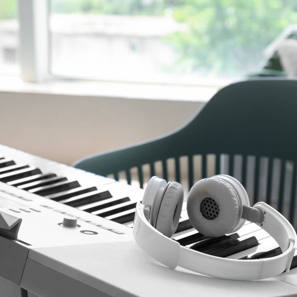 A White Headphones On Top Of A Portable Digital Piano
