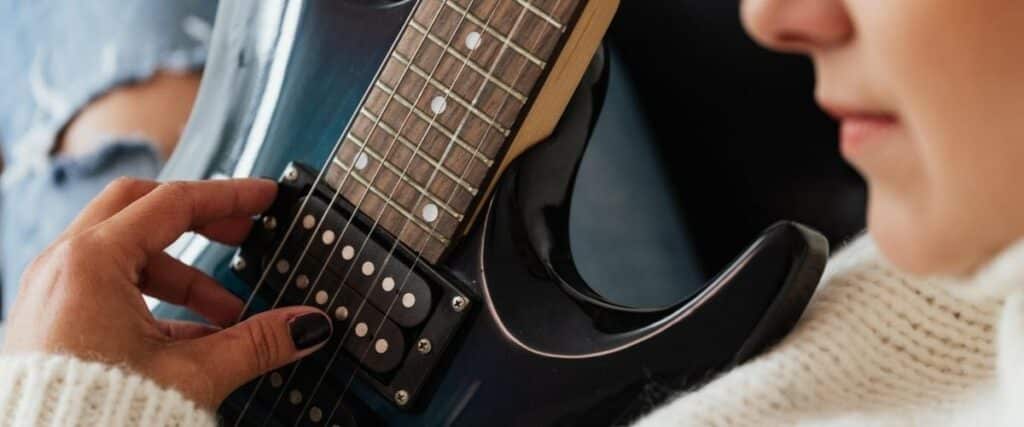 Stratocaster Review: Unveiling The Iconic Guitar'S Timeless Appeal An Electric Guitarist With Black Nails Playing An Electric Guitar