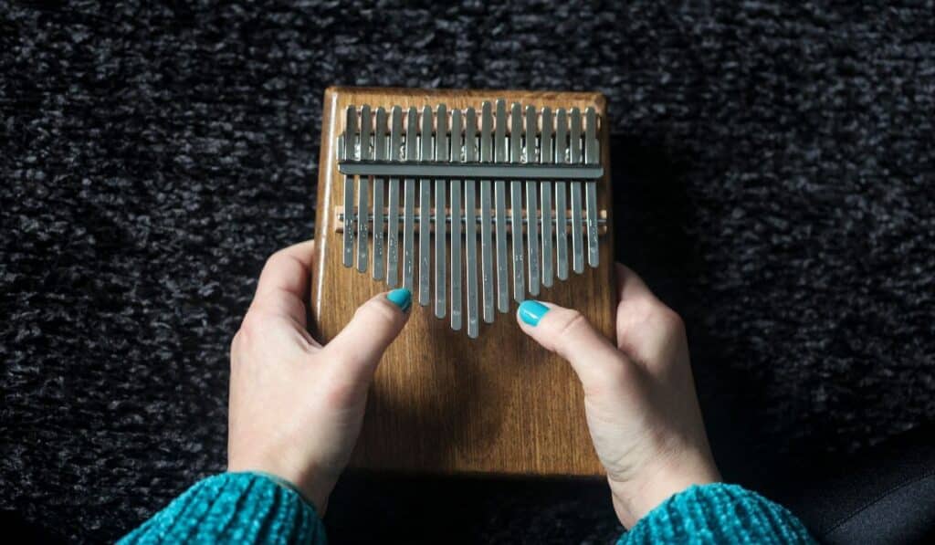 Smallest Instrument In The World A Hand With Blue Nail Polish Playing A Thumb Piano