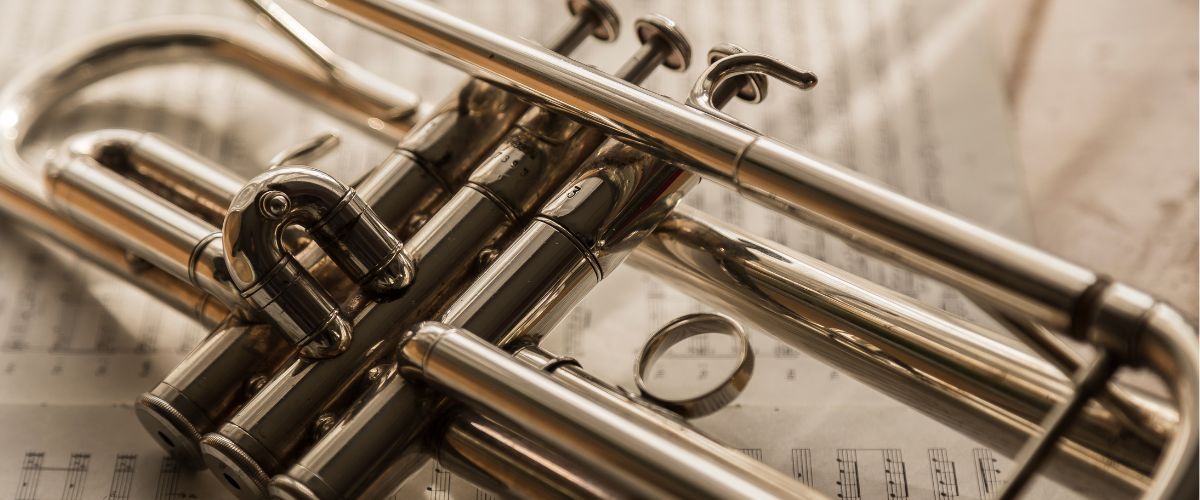 A Photo Of A Trumpet Focused On The Valves Resting On Top Of A Music Sheet A Photo Of A Trumpet Focused On The Valves Resting On Top Of A Music Sheet