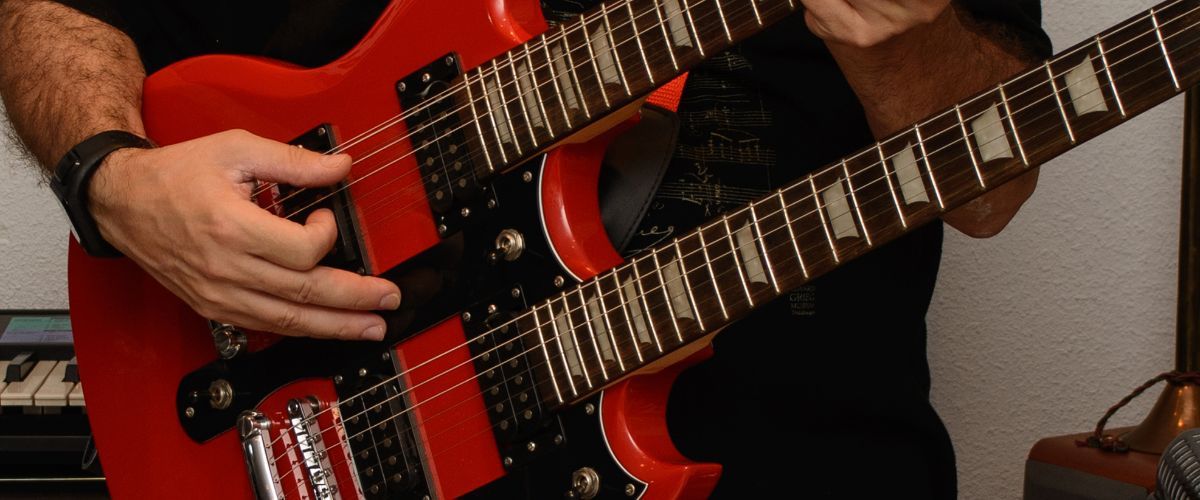 A Red Double Neck Electric Guitar Being Played By A Guitarist A Red Double Neck Electric Guitar Being Played By A Guitarist