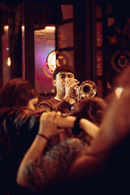 Can Playing The Trumpet Help You Live Longer? Scientists Think So! A Man Playing The Trumpet In A Crowded Bar