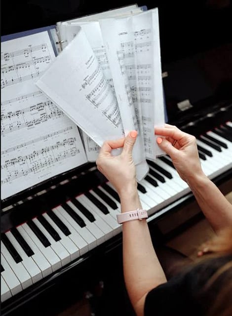 Person Holding Music Notes On Piano