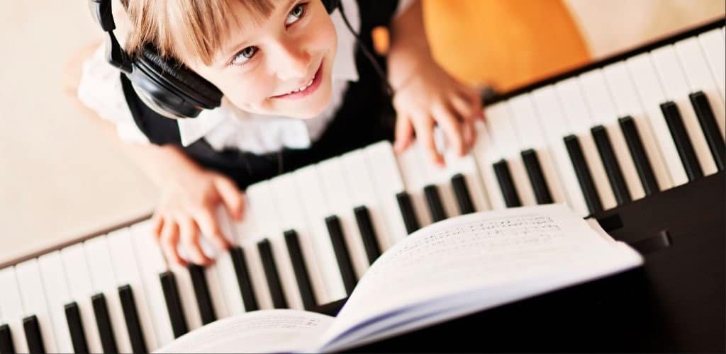 Roland Fp60X: Unlock Your Ultimate Piano Performance A Girl Playing The Digital Piano Smiling While Wearing Headphones