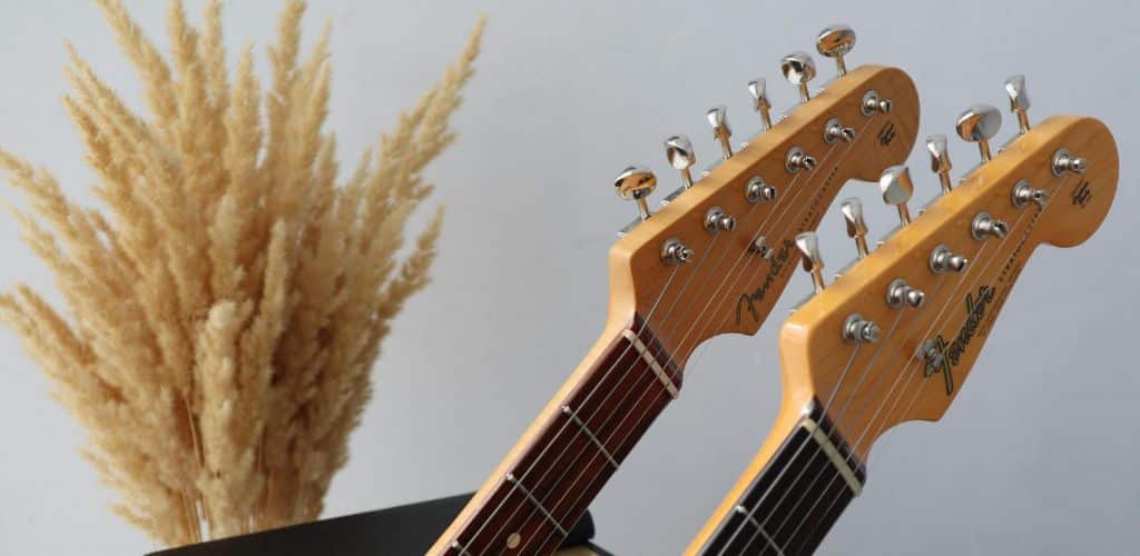 Stratocaster Review: Unveiling The Iconic Guitar'S Timeless Appeal A Photo Of Two Heads Of An Electric Guitar Leaning On An Amplifier