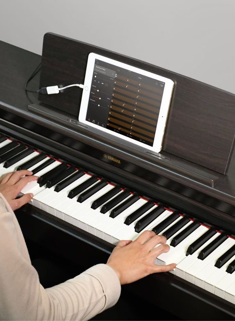 A Yamaha Product Image Showing Sa Smart App While Playing A Piano