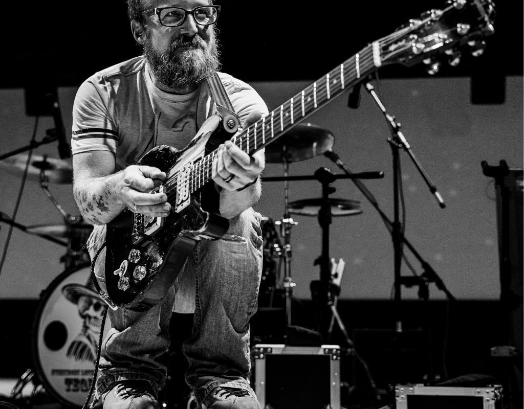 A Black And White Photo Of A Guitarist Wearing Shoes With Wheels While Playing The Guitar A Black And White Photo Of A Guitarist Wearing Shoes With Wheels While Playing The Guitar