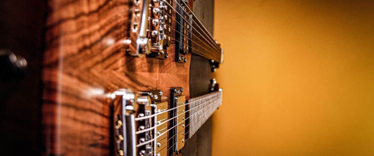 A Double Neck Electric Guitar On A Black Table And Brown Wall A Double Neck Electric Guitar On A Black Table And Brown Wall