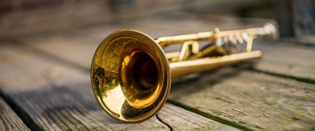 A Gold Trumpet On A Wooden Surface A Gold Trumpet On A Wooden Surface