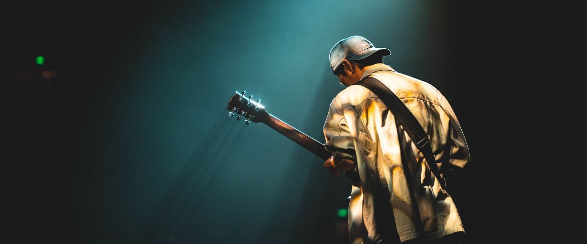 A Jazz Guitar Player Playing A Guitar On Stage