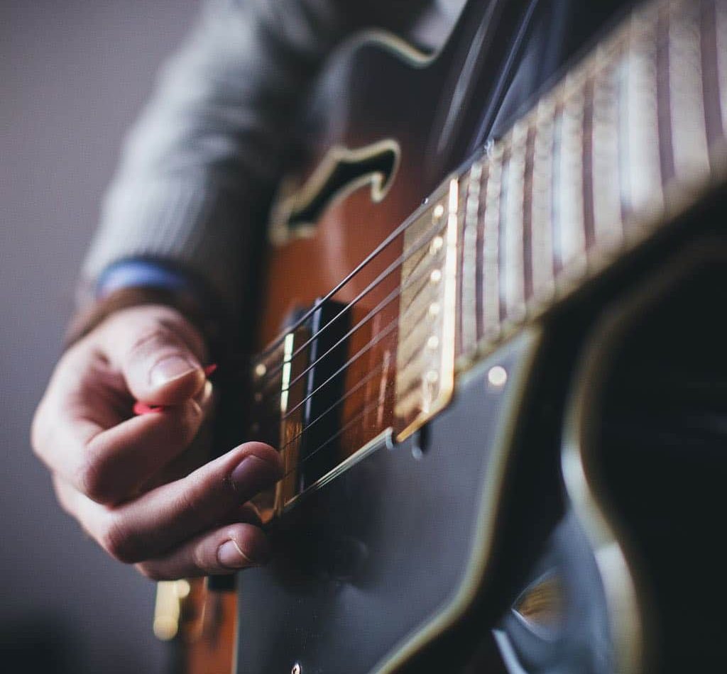 A Photo Of A Guitarist Hands Holding A Pick And Playing The Guitar A Photo Of A Guitarist Hands Holding A Pick And Playing The Guitar
