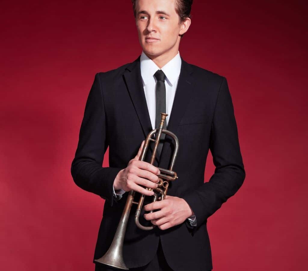 A Trumpet Player Wearing A Suit While Holding A Trumpet On A Red Background A Trumpet Player Wearing A Suit While Holding A Trumpet On A Red Background