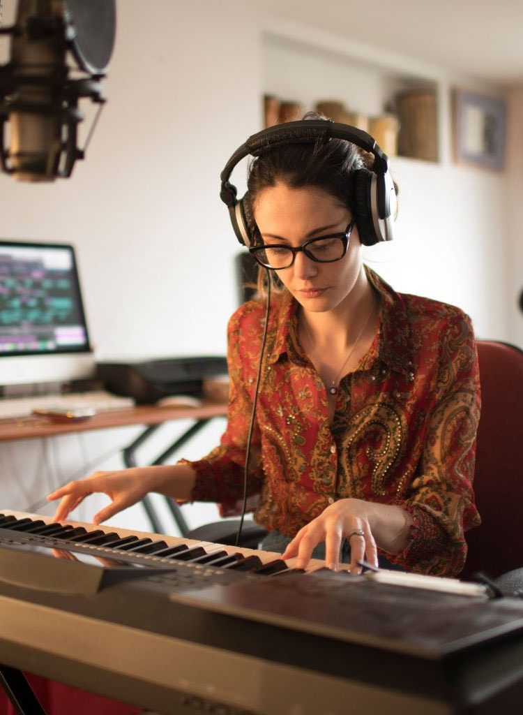 A Woman Recording And Editing Music Through A Piano Keyboard A Woman Recording And Editing Music Through A Piano Keyboard